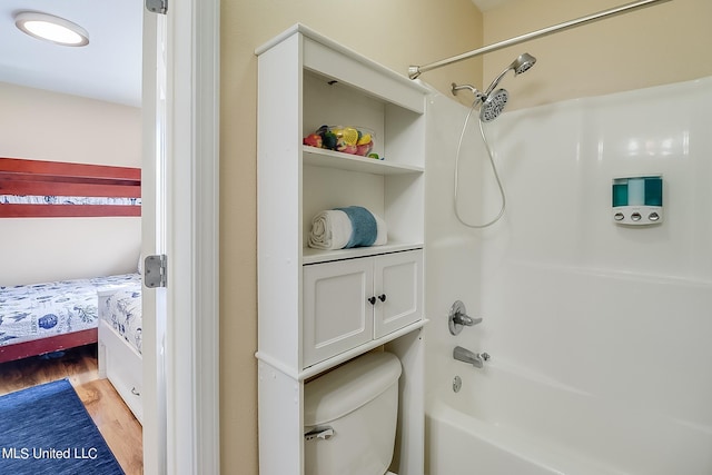 bathroom with toilet, wood-type flooring, and shower / tub combination