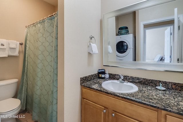 bathroom with vanity, toilet, tile patterned floors, and washer / clothes dryer