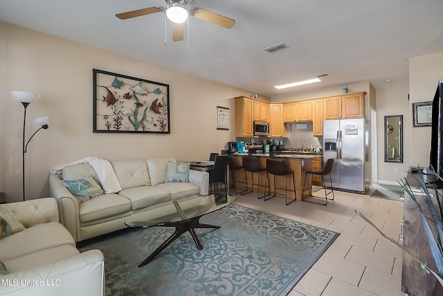 living room featuring sink and ceiling fan