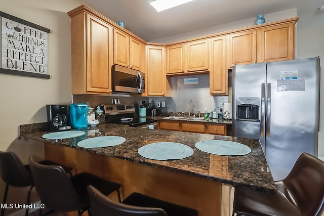 kitchen with stainless steel appliances, a kitchen bar, sink, and kitchen peninsula