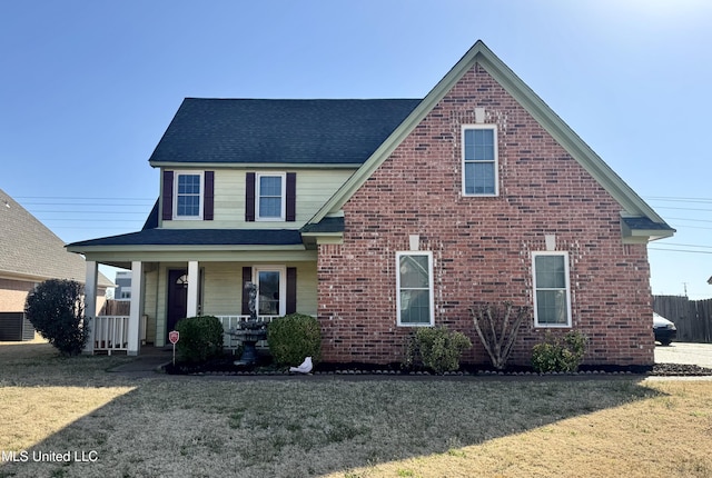 traditional-style home featuring a porch, brick siding, roof with shingles, and a front yard