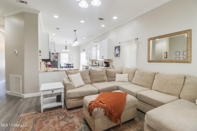 737 Ieke Cir, Diamondhead, MS 39525 - living room with wood finished floors, ornamental molding, a chandelier, recessed lighting, and baseboards