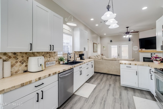 737 Ieke Cir, Diamondhead, MS 39525 - kitchen featuring a sink, appliances with stainless steel finishes, a ceiling fan, white cabinets, and crown molding