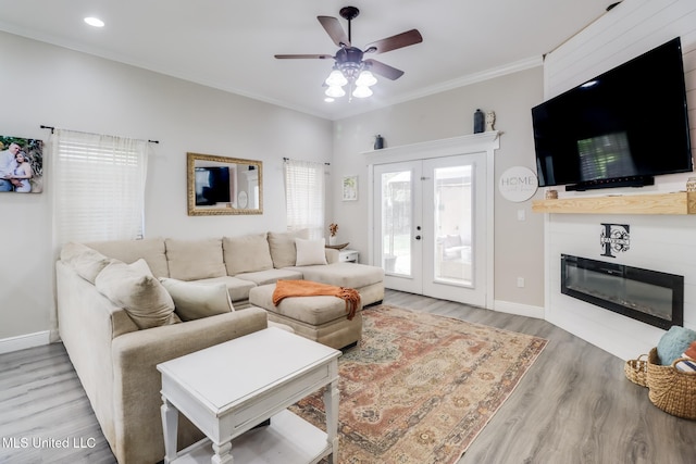737 Ieke Cir, Diamondhead, MS 39525 - living area featuring a ceiling fan, wood finished floors, baseboards, crown molding, and a glass covered fireplace
