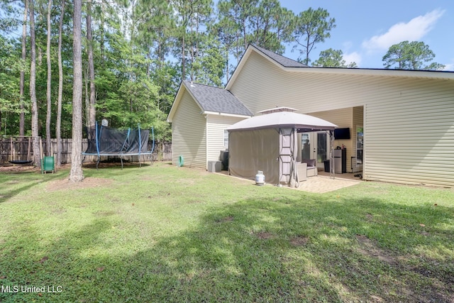 737 Ieke Cir, Diamondhead, MS 39525 - rear view of house with a trampoline, a gazebo, a patio area, and a shingled roof