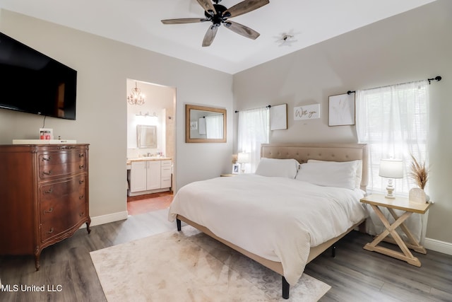 737 Ieke Cir, Diamondhead, MS 39525 - bedroom featuring wood finished floors, baseboards, connected bathroom, and a sink