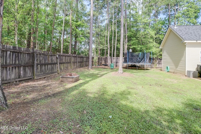 737 Ieke Cir, Diamondhead, MS 39525 - view of yard with a trampoline, an outdoor fire pit, and view of wooded area