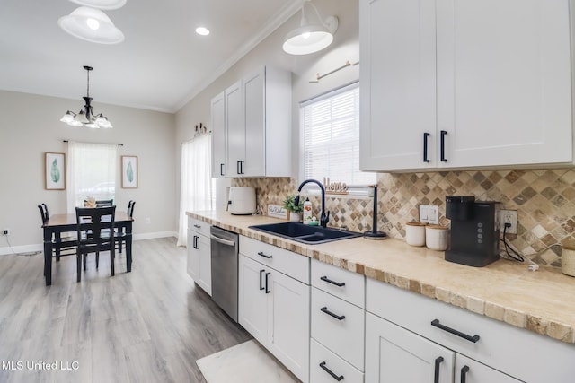 737 Ieke Cir, Diamondhead, MS 39525 - kitchen with dishwasher, a sink, light countertops, healthy amount of natural light, and crown molding