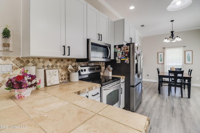 737 Ieke Cir, Diamondhead, MS 39525 - kitchen featuring appliances with stainless steel finishes, tasteful backsplash, a chandelier, and decorative light fixtures
