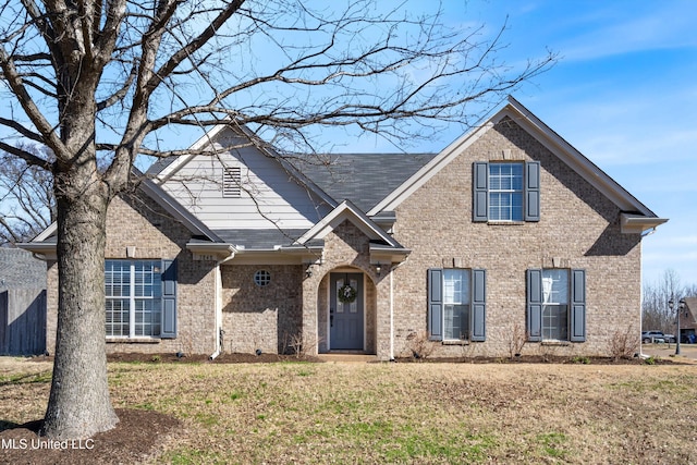 traditional-style house with brick siding and a front lawn