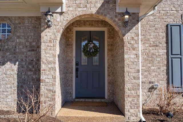 doorway to property featuring brick siding