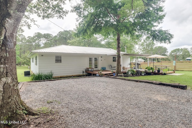 13120 Ridgeland Rd, Vancleave, MS 39565 - back of house featuring french doors, a wooden deck, a metal roof, and gravel driveway