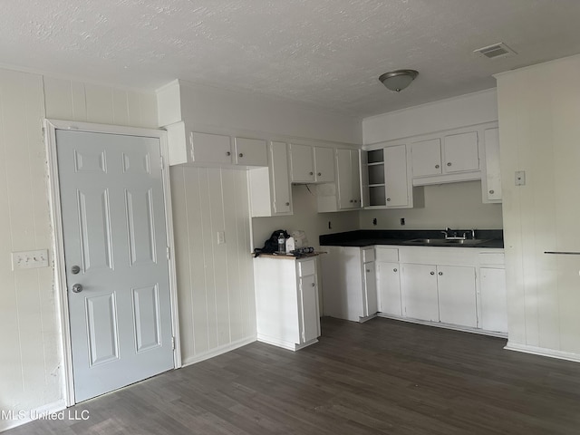 2806 Tara Rd, Jackson, MS 39212 - kitchen with a sink, dark wood-type flooring, a textured ceiling, baseboards, and dark countertops