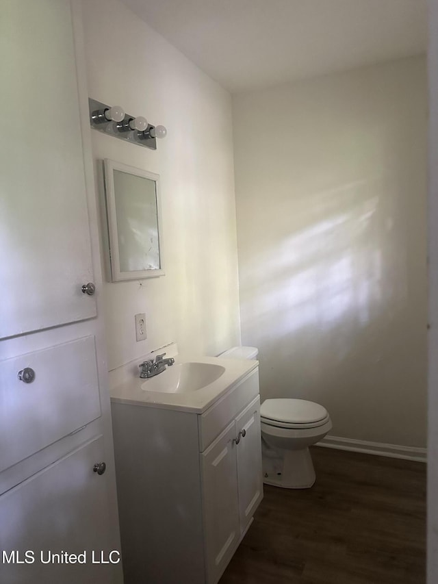 2806 Tara Rd, Jackson, MS 39212 - half bath featuring vanity, wood finished floors, toilet, and baseboards