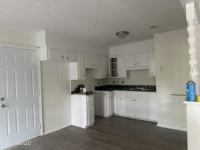 2806 Tara Rd, Jackson, MS 39212 - kitchen with dark wood-type flooring, a sink, a textured ceiling, baseboards, and dark countertops