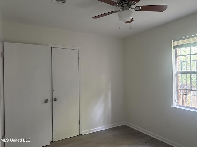 2806 Tara Rd, Jackson, MS 39212 - unfurnished bedroom featuring wood finished floors, multiple windows, baseboards, and ceiling fan