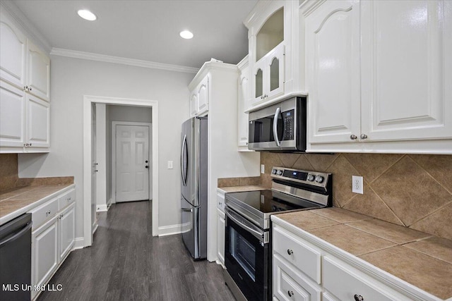 kitchen with white cabinets, stainless steel appliances, tile countertops, and dark wood-type flooring