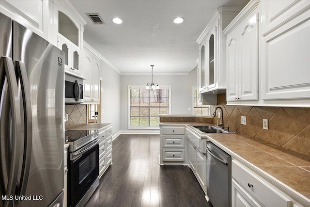 kitchen with white cabinets, stainless steel appliances, hanging light fixtures, and dark hardwood / wood-style floors