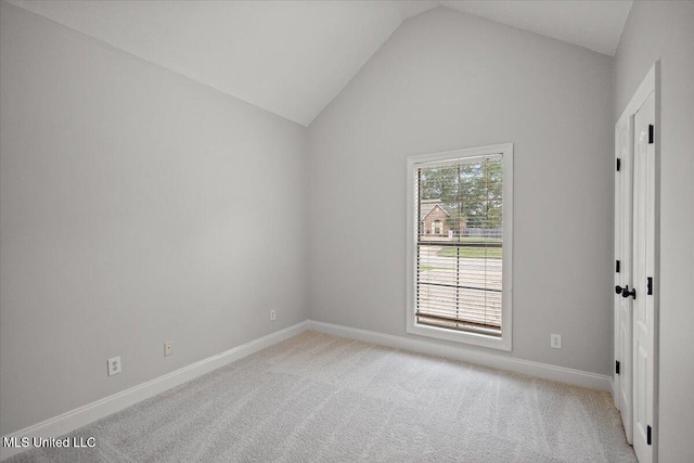 carpeted spare room featuring high vaulted ceiling