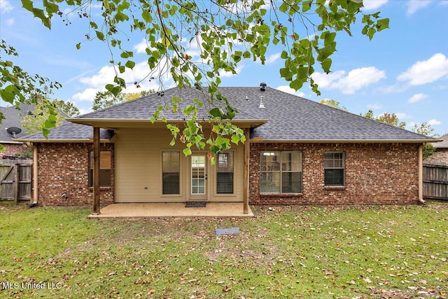 rear view of house featuring a lawn and a patio