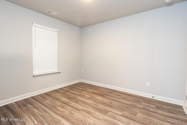 spare room featuring wood-type flooring