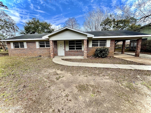 single story home featuring an attached carport, concrete driveway, and brick siding