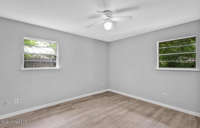 unfurnished room featuring wood finished floors, ceiling fan, and baseboards