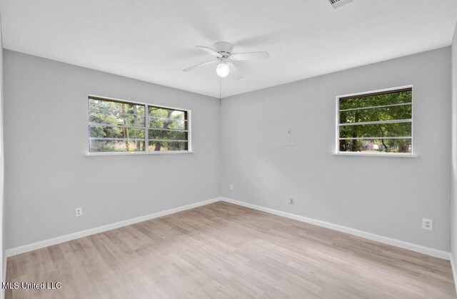 unfurnished room featuring wood finished floors, a ceiling fan, and baseboards