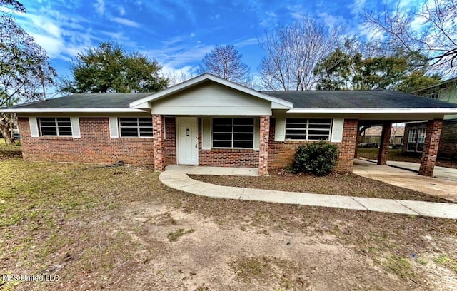 single story home with concrete driveway, an attached carport, and brick siding