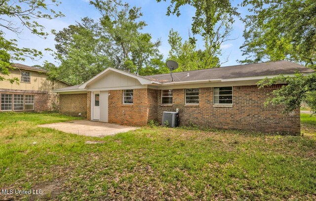 back of house with a lawn, brick siding, cooling unit, and a patio area