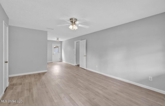 spare room with a ceiling fan, baseboards, and light wood-style floors