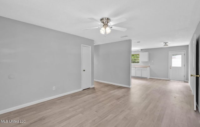 unfurnished living room featuring baseboards, ceiling fan, and light wood finished floors