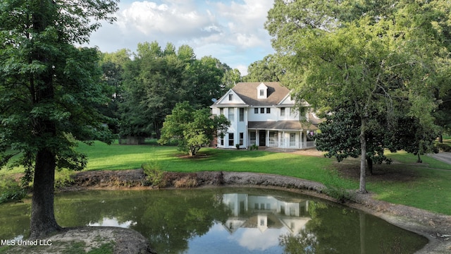 exterior space with a water view and a lawn