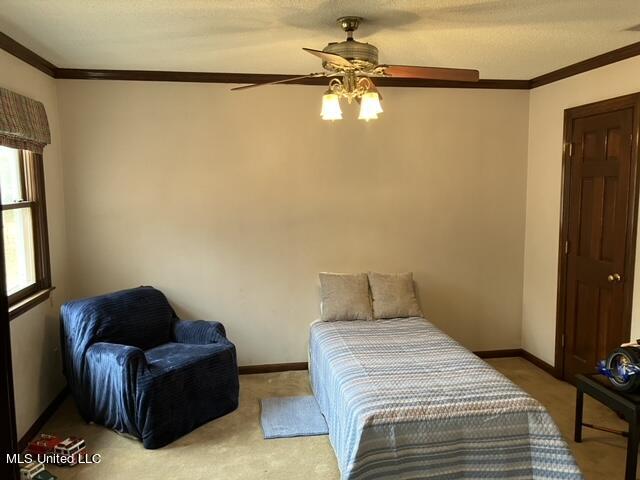 bedroom with crown molding, carpet flooring, and ceiling fan