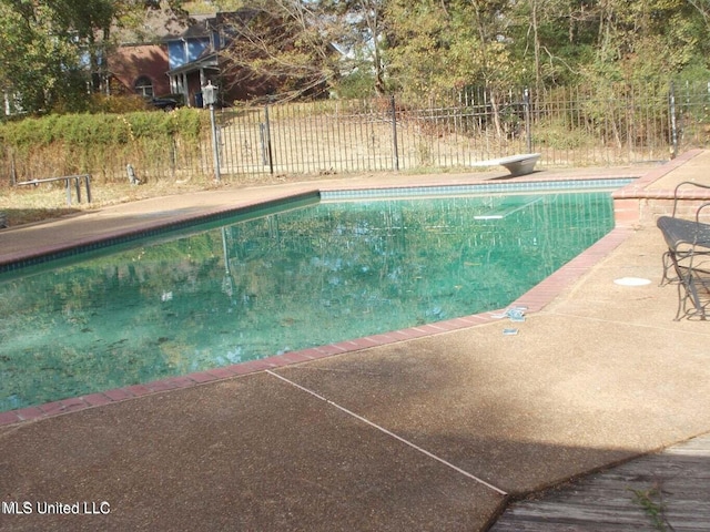 view of swimming pool featuring a diving board