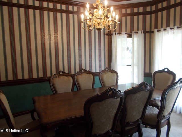 dining room with crown molding, a wealth of natural light, and an inviting chandelier