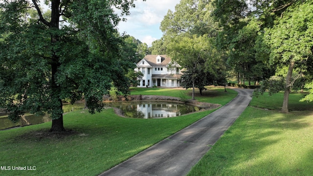 view of property's community with a yard and a water view