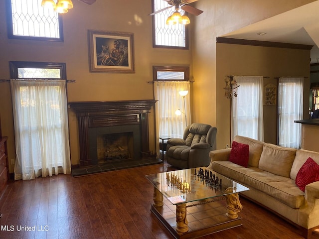 living room featuring a healthy amount of sunlight, dark wood-type flooring, and ceiling fan