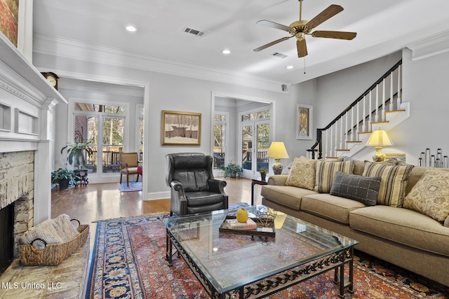 living room featuring a wealth of natural light, a fireplace, ceiling fan, and wood-type flooring