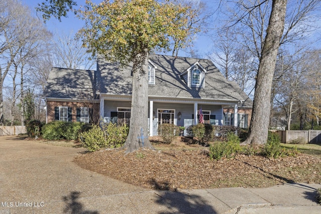 cape cod home featuring a porch