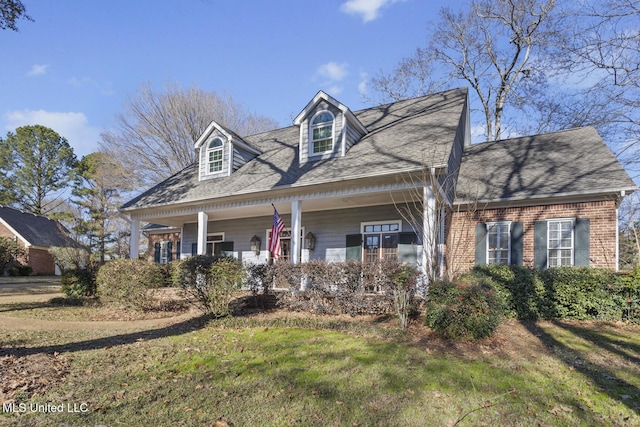 cape cod house with a front lawn and covered porch