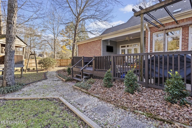 view of yard with a wooden deck and ceiling fan