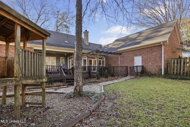 rear view of property featuring a lawn and a wooden deck