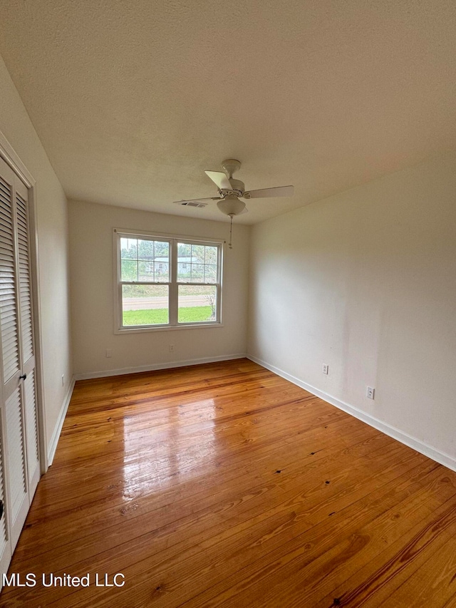 unfurnished room featuring light hardwood / wood-style flooring, a textured ceiling, and ceiling fan