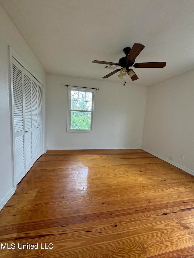 unfurnished bedroom featuring a closet, light wood-type flooring, and ceiling fan