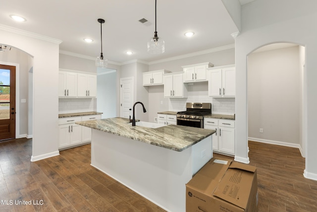 kitchen with stainless steel range with gas stovetop, sink, an island with sink, and white cabinetry