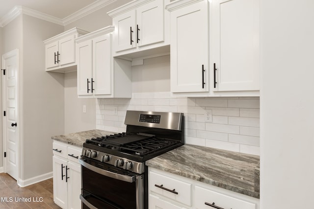 kitchen featuring decorative backsplash, stainless steel gas stove, ornamental molding, white cabinets, and light stone counters