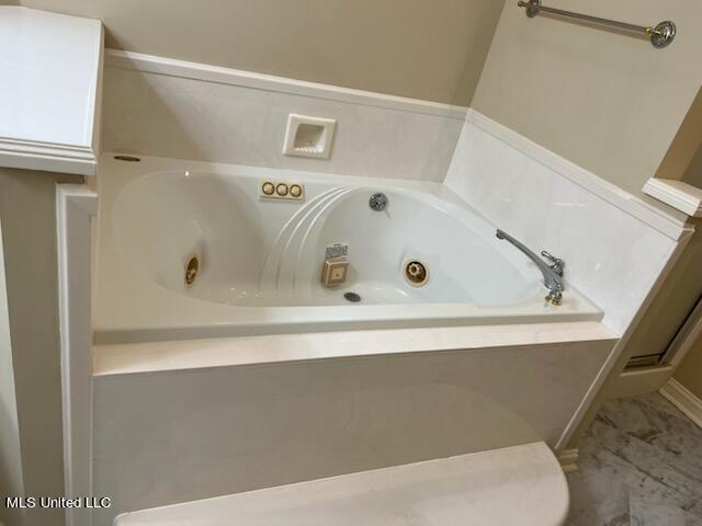 bathroom featuring a relaxing tiled tub