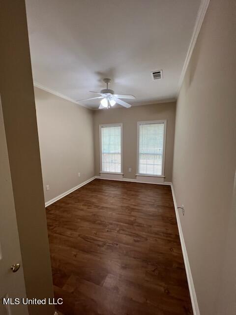 unfurnished room featuring ceiling fan, ornamental molding, and dark hardwood / wood-style flooring