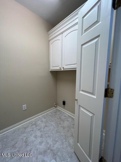 clothes washing area with cabinets